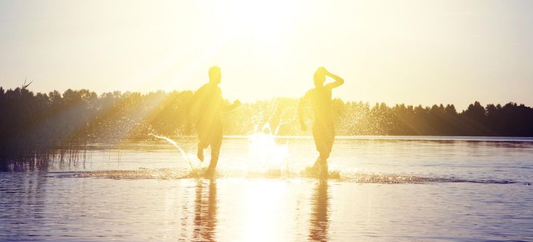 Group of young people playing games on sandy beach on a summer day.