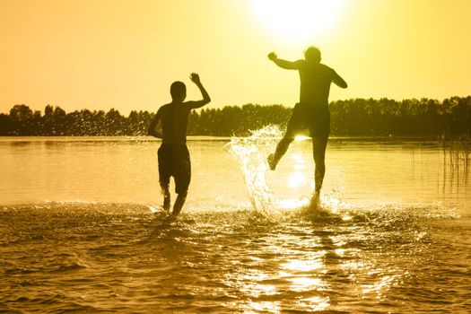 Group of young people playing games on sandy beach on a summer day.