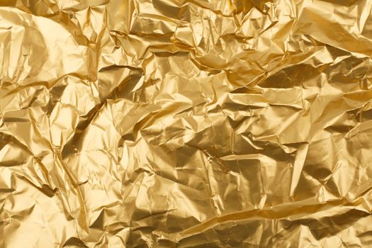 Gold crumpled paper texture background with space for text. Crumpled wrapping paper abstract background. Concept of template for Christmas design or presents and gifts concept