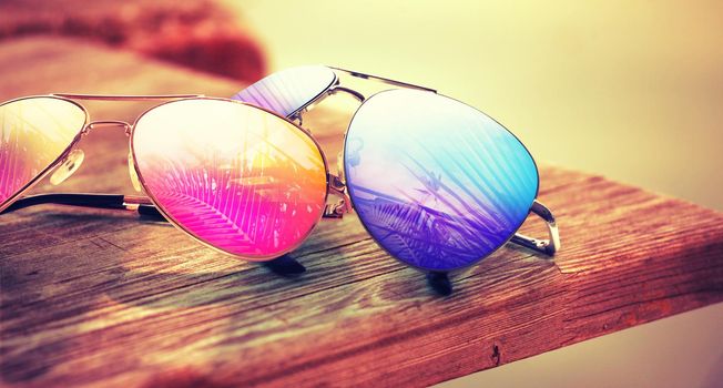 Summer vacation concept. Sunglasses with ocean beach and palms.