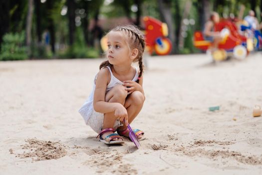 Little Girl Playing Sandbox Playground Digging Sand Shovel Building Sand Figure Summer Day. Caucasian Female Child 5 years Have Fun Outdoor