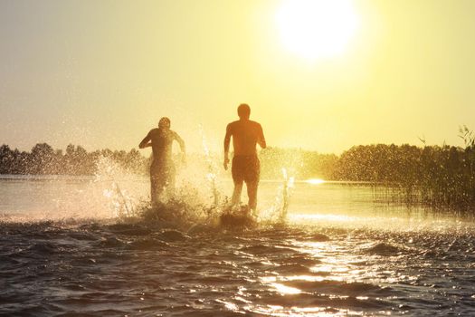 Group of young people playing games on sandy beach on a summer day.