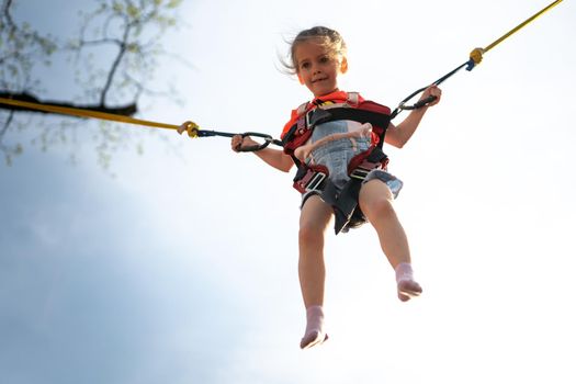 Child jumping child trampoline rubber bands Amusement park Little girl jump on attraction