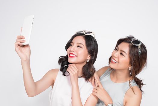 Portrait of two beautiful asian fashionable women taking selfie