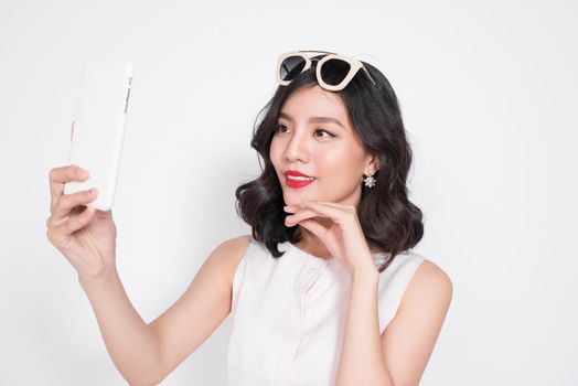 Portrait of beautiful asian fashionable girl taking selfie