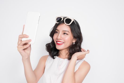 Portrait of beautiful asian fashionable girl taking selfie