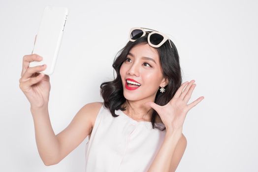 Portrait of beautiful asian fashionable girl taking selfie