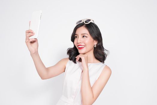 Portrait of beautiful asian fashionable girl taking selfie