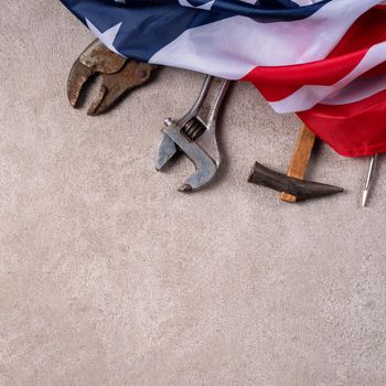 Top view design concept of American Labor Day with working tools on gray table background.