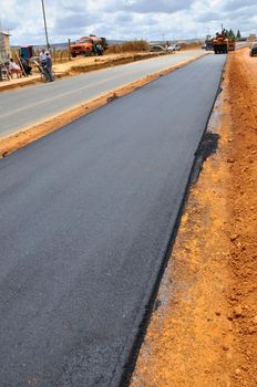 vitoria da conquista, bahia, brazil -  september 15, 2011: Machines and workers are seen doing asphalt resurfacing on an avenue in the city of Vitoria da Conquista.