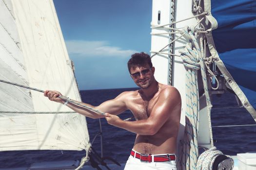 Man enjoying summer time holiday on sailing boat.