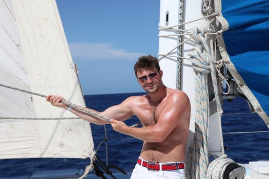Man enjoying summer time holiday on sailing boat.