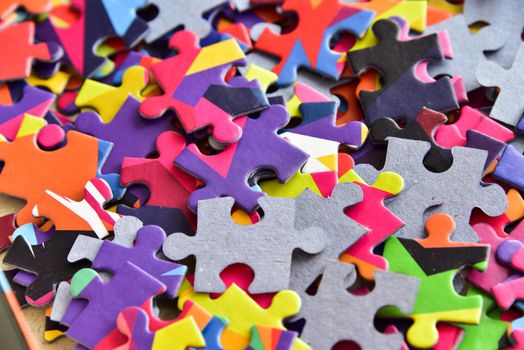 closeup heap of colorful jigsaw puzzle game in a box.