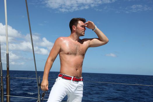 Man enjoying summer time holiday on sailing boat.