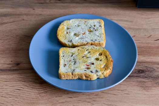 Two slices of bread in a plate on vintage wooden background.