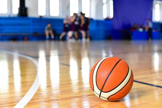 Basketball ball on Court Floor close up with blurred background.