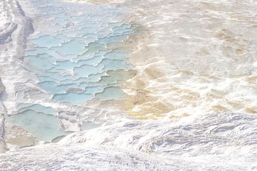 Background texture with abstract pattern in pastel natural colors. Pamukkale calcium travertine in Turkey, top view.