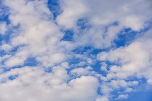 blue sky background with cumulus white clouds.