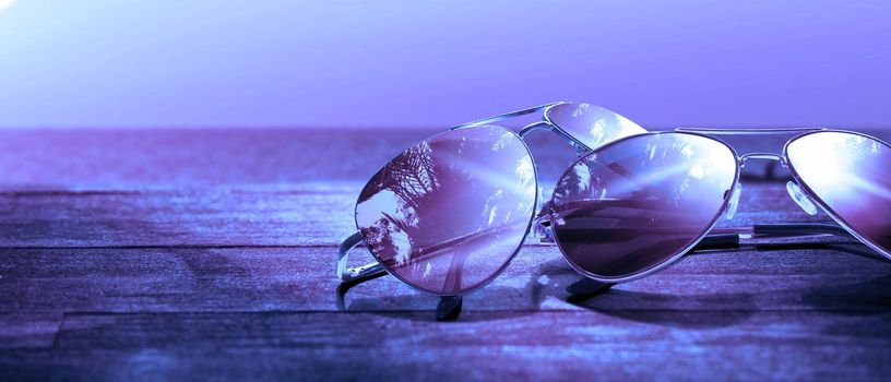 Summer vacation concept. Sunglasses with ocean beach and palms.