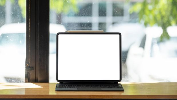 shot of digital tablet with blank white screen on wooden desk.