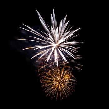 Colorful celebration fireworks isolated on a black sky background.