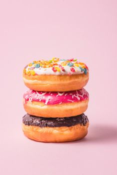 Delicious donuts for birthday on pastel pink background.