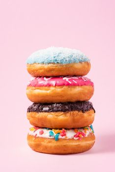 Delicious donuts for birthday on pastel pink background.