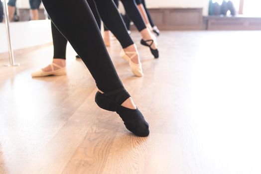 low section of The graceful legs of ballet dancers standing in a row on their toes