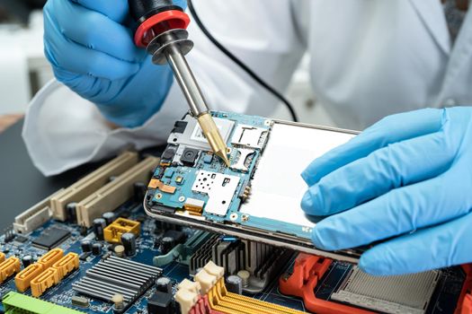 E-waste, technician repairing inside of hard disk by soldering iron. Integrated Circuit. the concept of data, hardware, technician and technology.