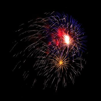 Colorful celebration fireworks isolated on a black sky background.