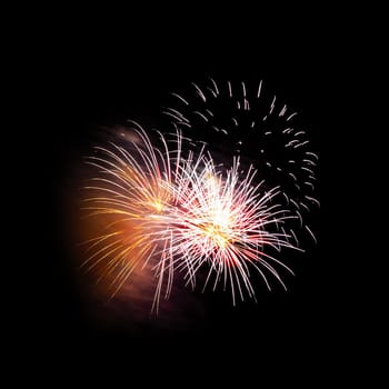 Colorful celebration fireworks isolated on a black sky background.