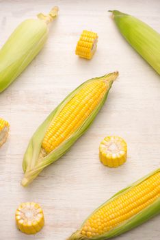 Sweet corns. Fresh corn on cobs on wooden table.