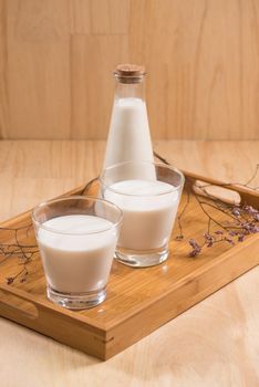Dairy products. A bottle of milk and glass of milk on a wooden table.