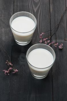 Dairy products. Two glasses of milk on a rustic wooden table.