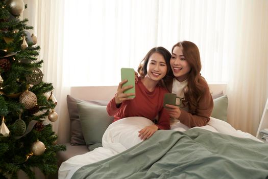 Young Asian Girls doing selfie on the bed