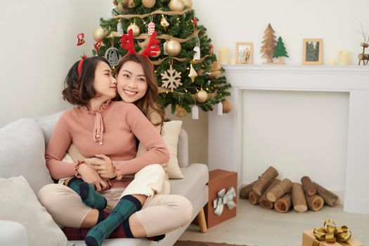 Two beautiful girls near the Christmas tree waiting for gifts