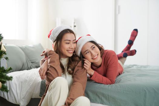 Two beautiful girls near the Christmas tree waiting for gifts