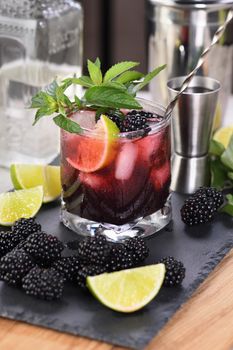 Blackberry summer mojito cocktail. Cold refreshing organic alcoholic drink with berries, lime, mint