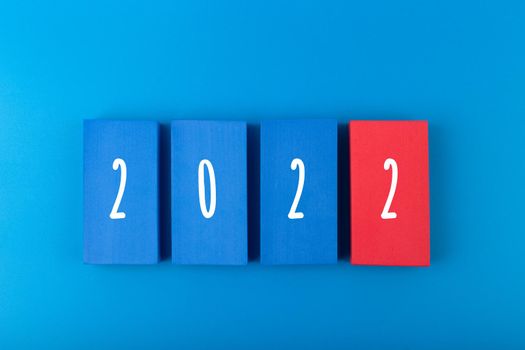 New Year 2022 blue minimal trendy concept. Modern elegant composition with blue toy blocks with written 2022 numbers on blue background