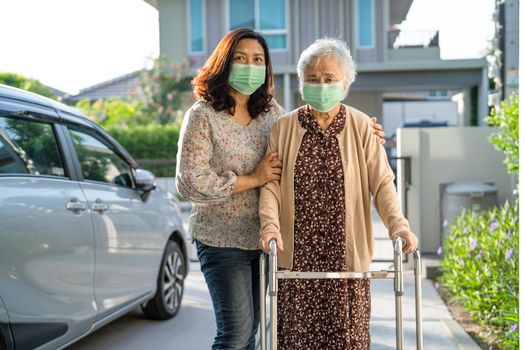 Asian senior or elderly old lady woman walk with walker and wearing a face mask for protect safety infection Covid-19 Coronavirus.