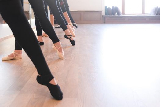 low section of The graceful legs of ballet dancers standing in a row on their toes