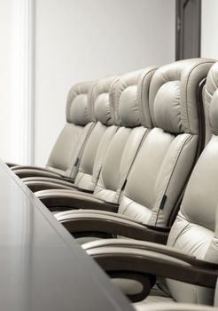 conference room with wooden table and beige leather armchairs