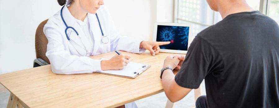 Medical Doctor Advising Coronavirus Disease and Health Care Consulting to Her Patient in Examination Room, Female Physician Doctor is Explaining Corona Virus Pandemic to Patient. Coronavirus Crisis