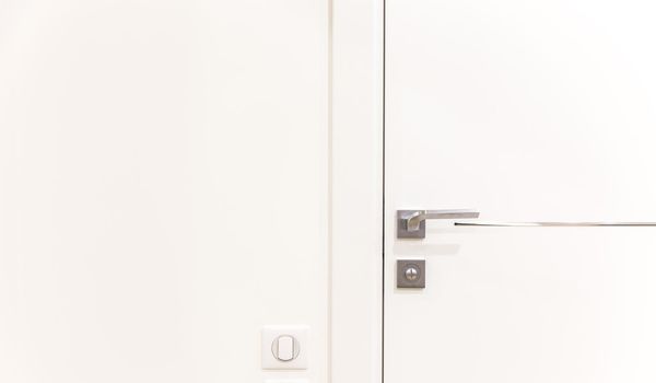 Metalic doorknob on a white modern door