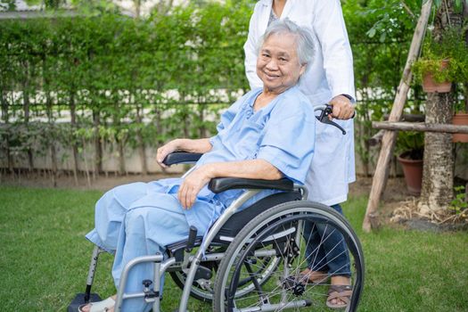 Doctor help and care Asian senior or elderly old lady woman patient sitting on wheelchair at park in nursing hospital ward, healthy strong medical concept.