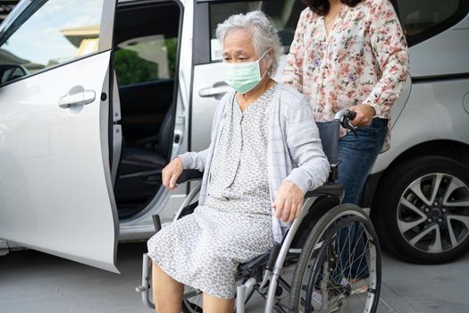 Help and support asian senior or elderly old lady woman patient sitting on wheelchair prepare get to her car, healthy strong medical concept.