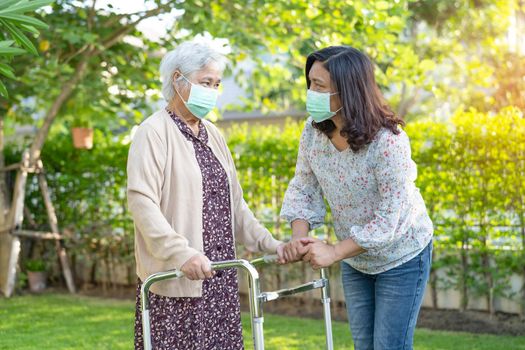 Asian senior or elderly old lady woman walk with walker and wearing a face mask for protect safety infection Covid-19 Coronavirus.