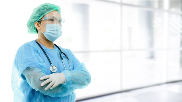 Asian doctor wearing face shield and PPE suit new normal to check patient protect safety infection Covid-19 Coronavirus outbreak at quarantine nursing hospital ward.