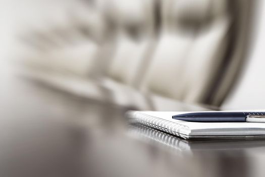 Closeup of notepad kept on table in empty conference room