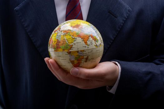 Businessman is standing with an earth globe fot business concept